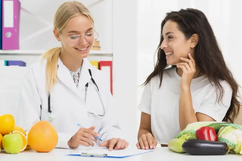 Doctora conversando con una paciente en un consultorio médico.